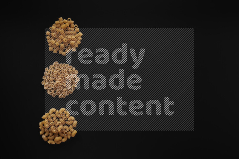 Different pasta types in 3 bunches on black background