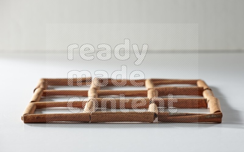9 empty squares of cinnamon sticks on white flooring