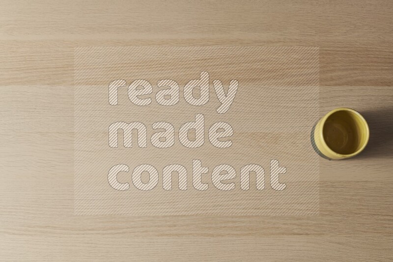 كأس فخاري متعدد الألوان على خلفية خشبية فاتحة