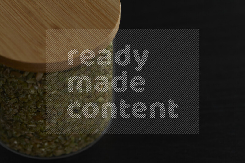 Freekeh in a glass jar on black background