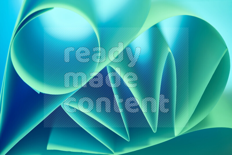 عرض فني لطيات الورق تخلق مزيج من الأشكال الهندسية، مضاءة بإضاءة ناعمة بدرجات اللون الأخضر والأزرق