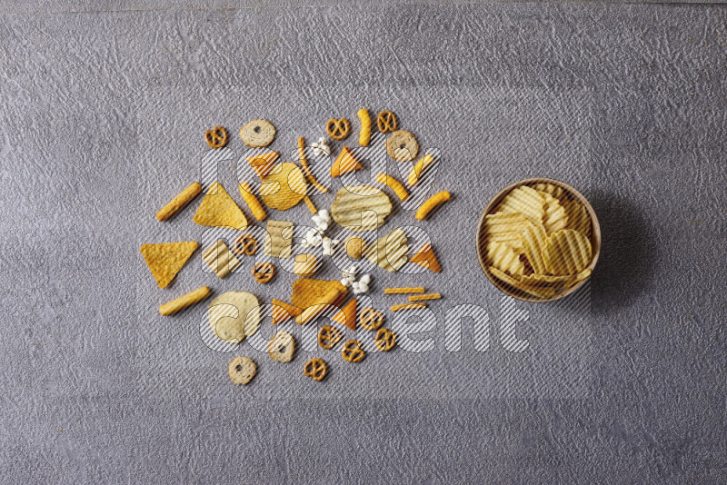Assorted snacks in pottery bowls on grey background