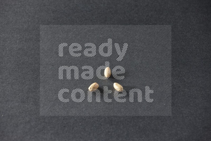 3 حبات من الفول السوداني المقشر علي خلفية سوداء