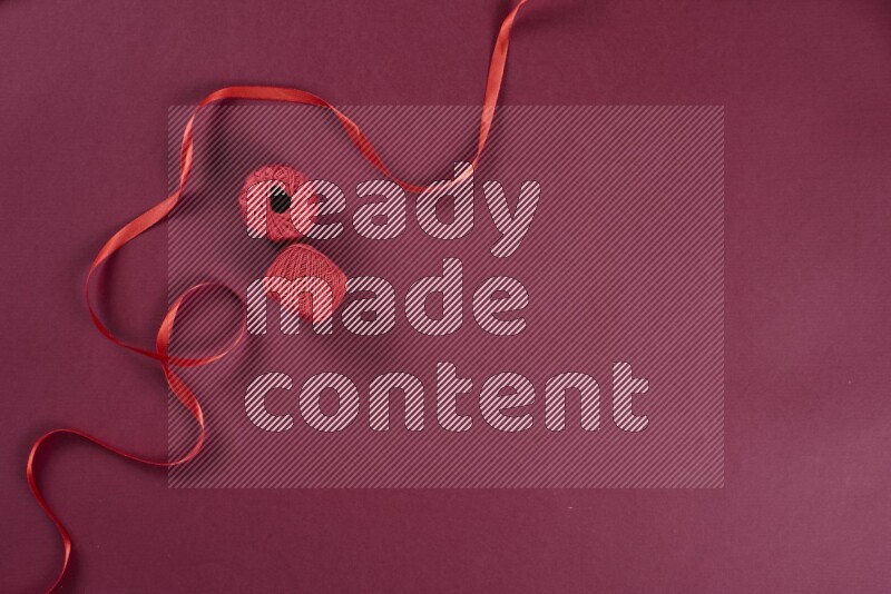 مجموعة من أدوات الخياطة والتفصيل حمراء اللون على خلفية حمراء