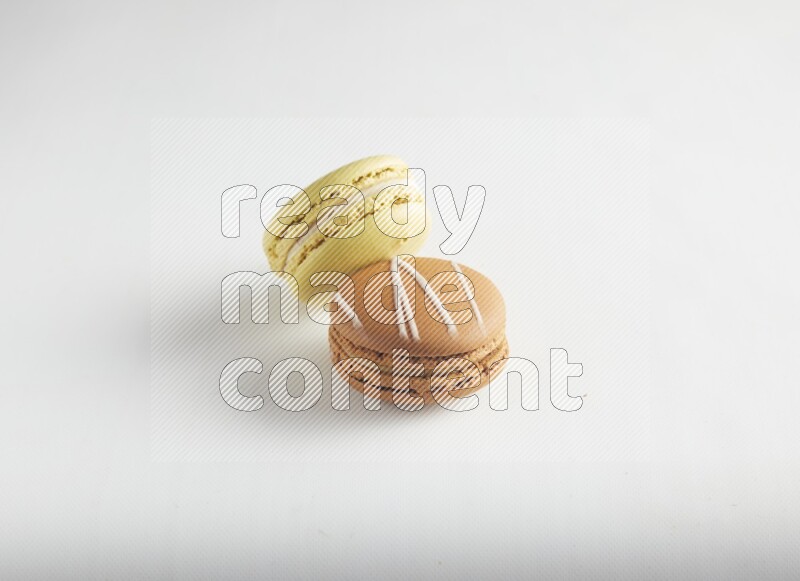 45º Shot of of two assorted Brown Irish Cream, and Yellow Lime macarons on white background