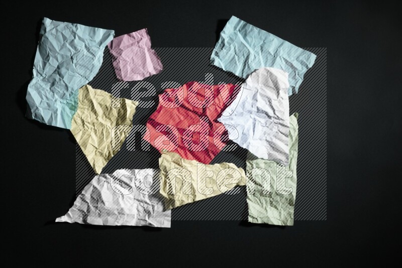 Crumpled multicolored paper on black background