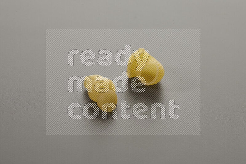 Snails pasta with other types of pasta on grey background
