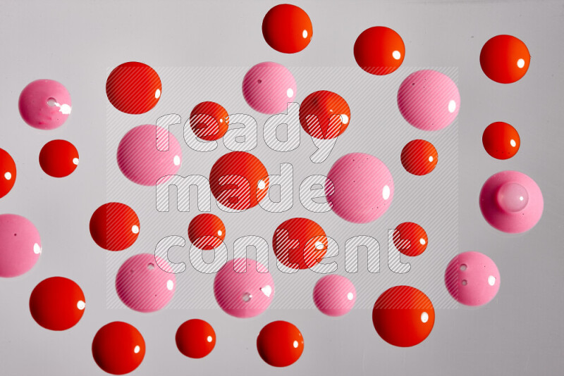Close-ups of abstract pink and red paint droplets on the surface