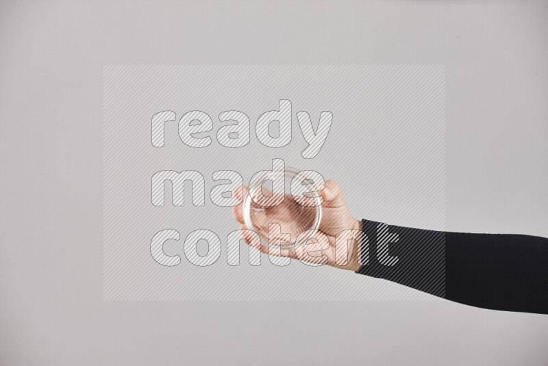 A woman in black abaya holding different glassware in different positions