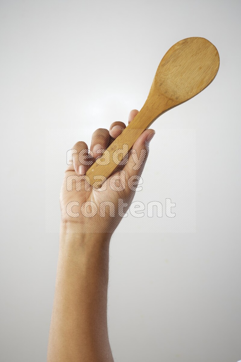 Male Hand Holding Wooden spoon on white background