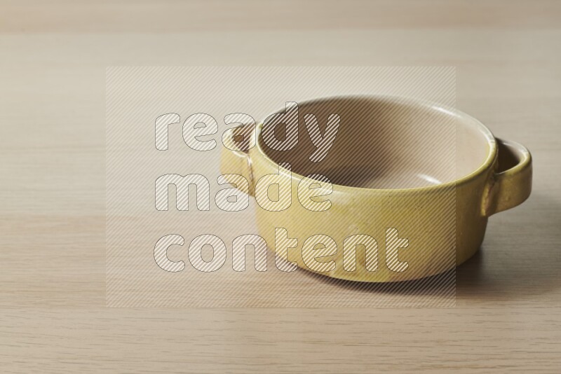 A multicolored pottery bowl on light wooden background