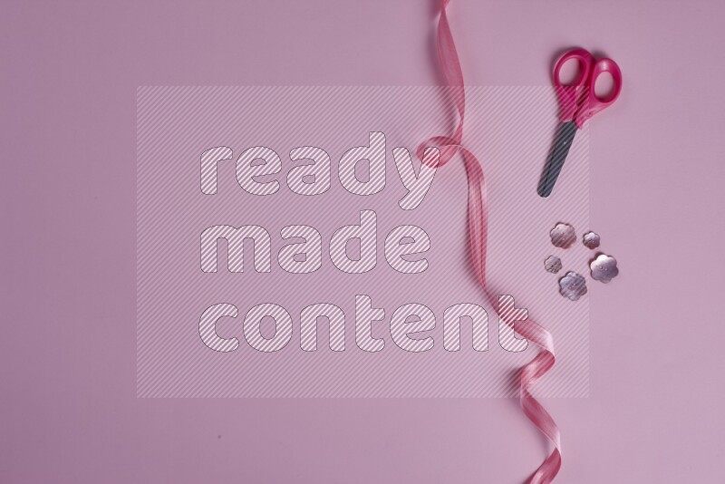 مجموعة من أدوات الخياطة والتفصيل زهرية اللون على خلفية زهرية