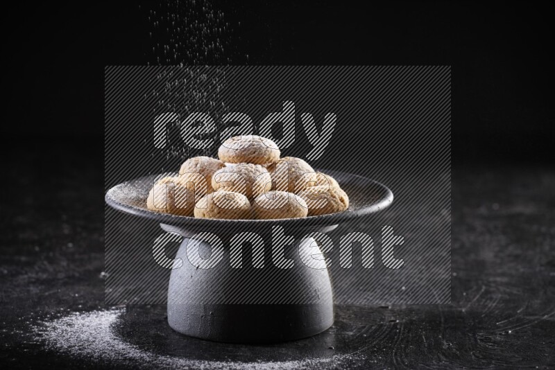 Kahk on a serving plate on a black background