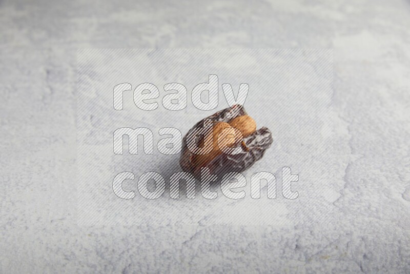 almond stuffed madjoul date on a light grey background