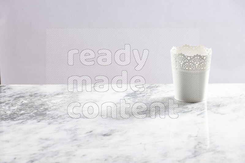 An empty white plant pot on grey marble background