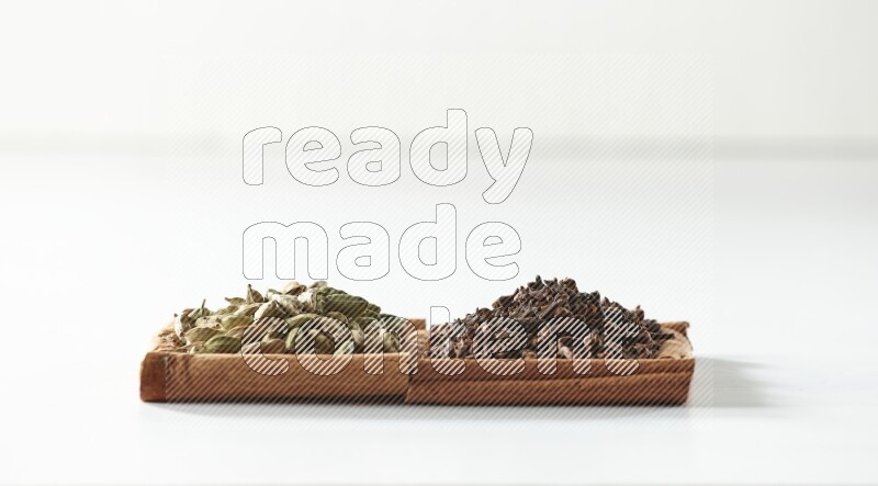 2 squares of cinnamon sticks full of cloves and cardamom on white flooring