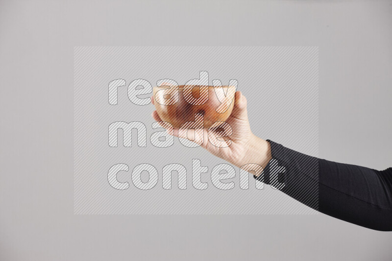 امرأة ترتدي عباءة سوداء تحمل أدوات خشبية مختلفة في أوضاع متعددة