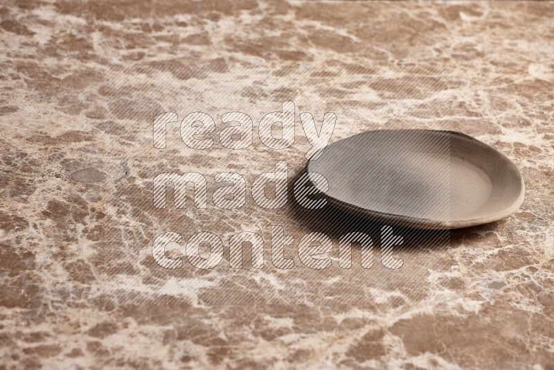 A multicolored pottery plate on beige marble background