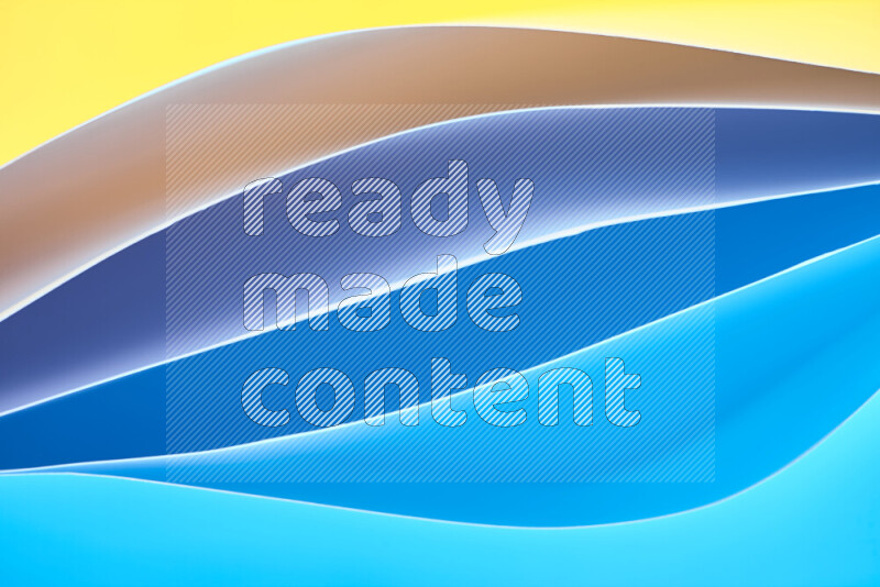 This image showcases an abstract paper art composition with paper curves in blue and yellow gradients created by colored light
