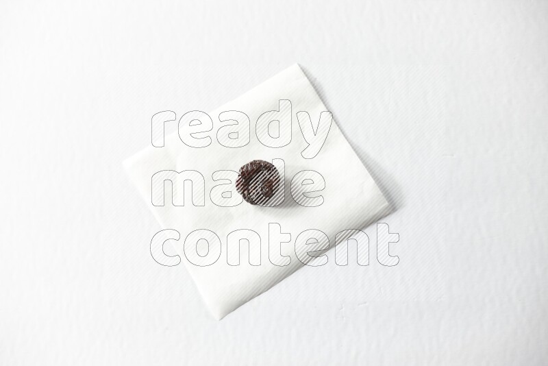 A dried plum on a piece of paper on a white background in different angles