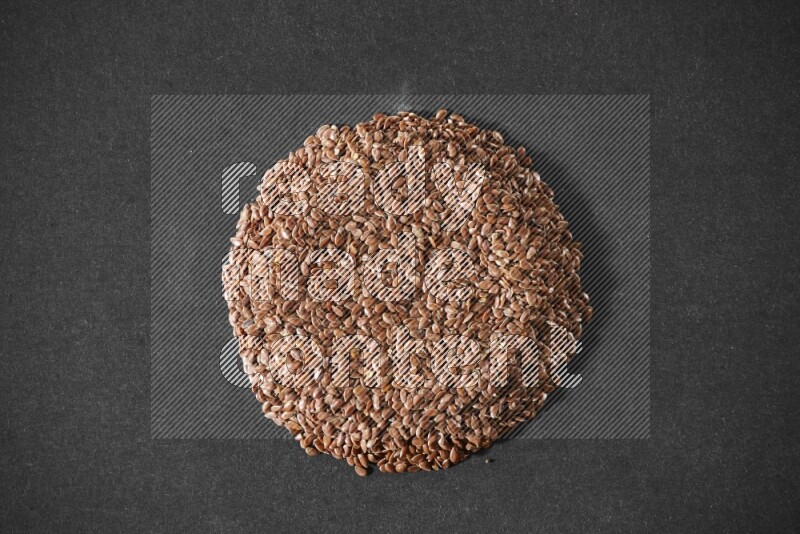 Flax Seeds in a circle shape on a black Flooring