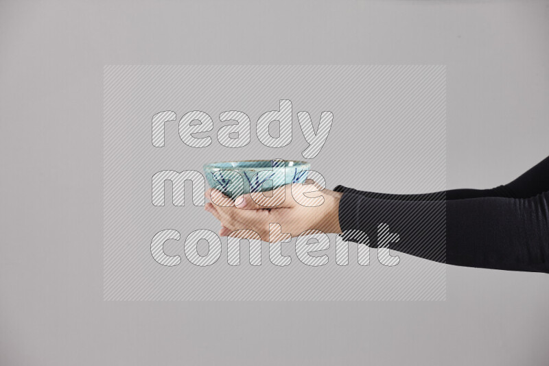 امرأة ترتدي عباءة سوداء تحمل أدوات فخارية مختلفة في أوضاع متعددة