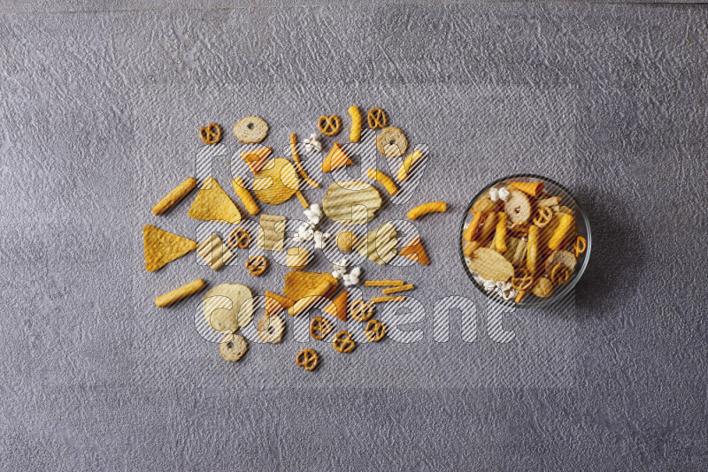 Assorted snacks in pottery bowls on grey background