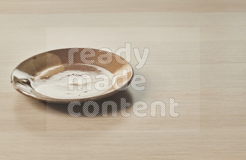 A multicolored pottery plate on light wooden background