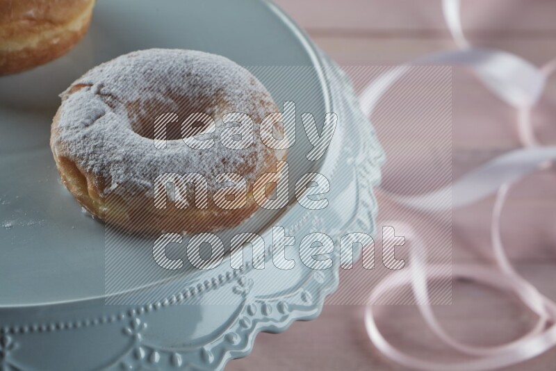 Sugar dusted doughnut on pink wooden background