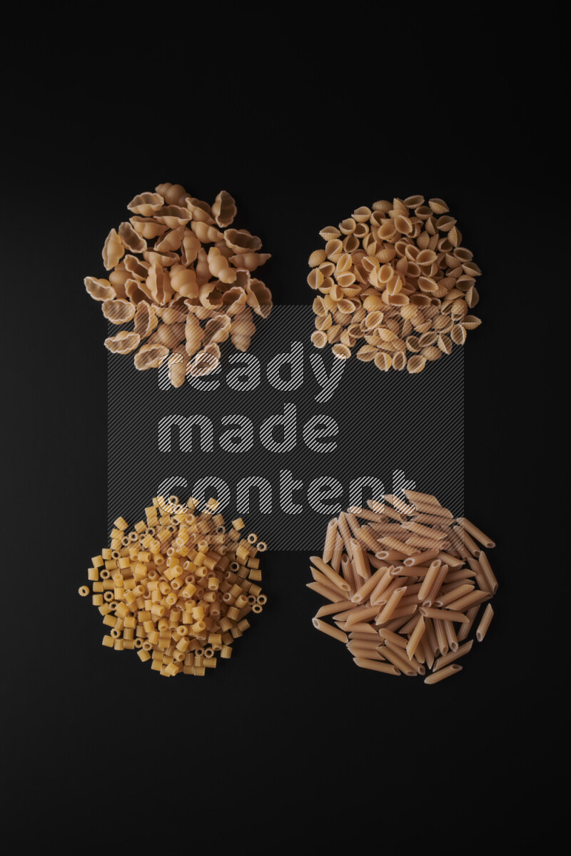 Different pasta types in bunches on black background