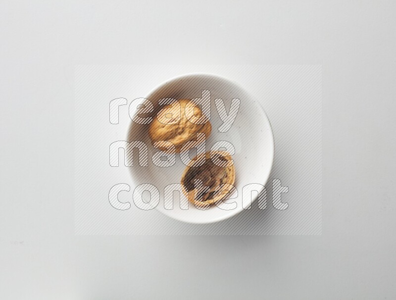 Top-view shot of walnut in a container on white background