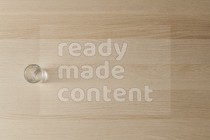 An empty glass cup on light wooden background