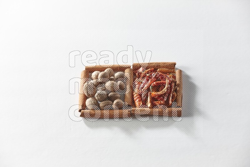 2 squares of cinnamon sticks full of dried red chilis and nutmegs on white flooring