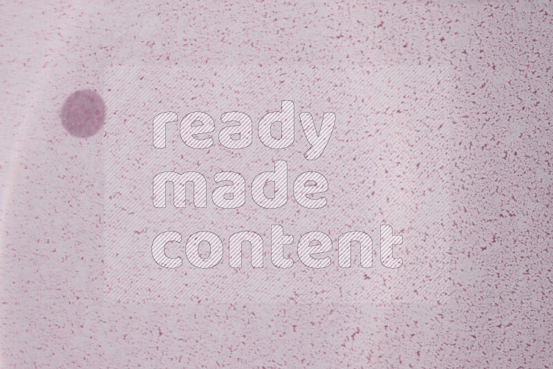 The image captures a dramatic splatter of purple paint over a white backdrop