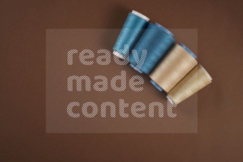 A blue collection of sewing and tailoring tools arranged on a brown background
