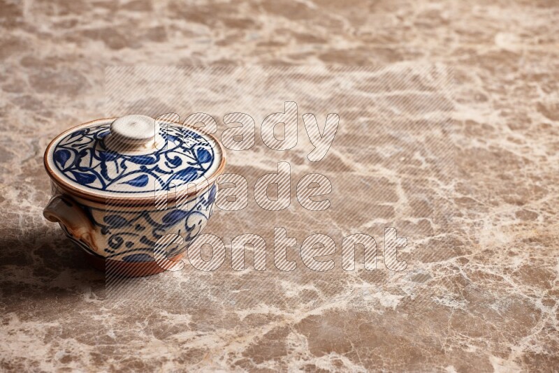 A decorative pottery bowl on beige marble background