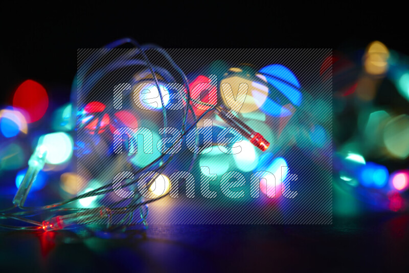 Light bulbs glowing against backdrop of multicolord bokeh