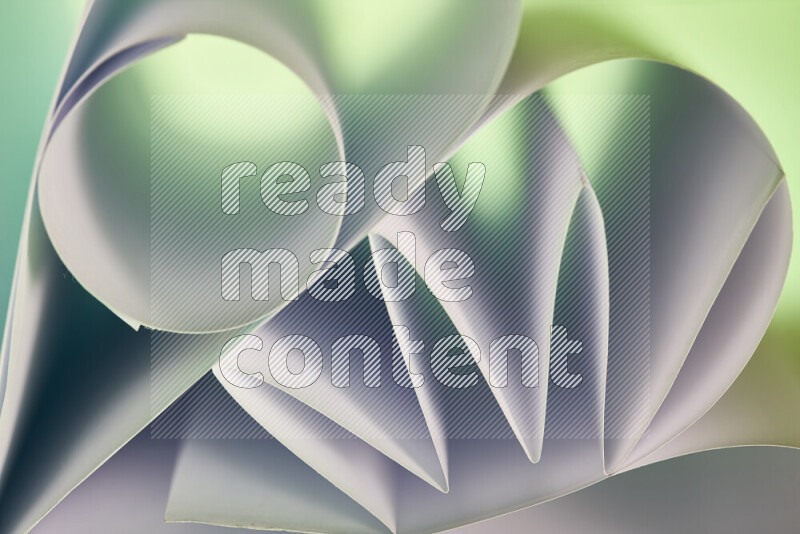 عرض فني لطيات الورق تخلق مزيج من الأشكال الهندسية، مضاءة بإضاءة ناعمة بدرجات اللون الأخضر والأحمر