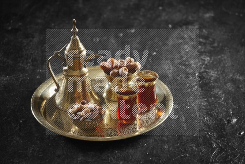 حلويات شرقية مع تمر ومشروب ساخن على صينية معدنية