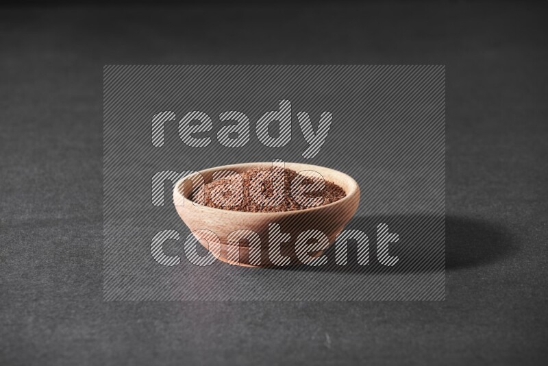 وعاء خشبي ممتلئ ببذور حب الرشاد علي خلفية سوداء