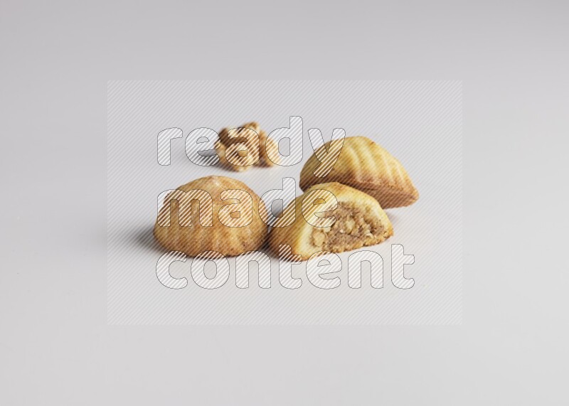 Three Pieces of Maamoul filled with walnut paste  one of them is cut direct on white background