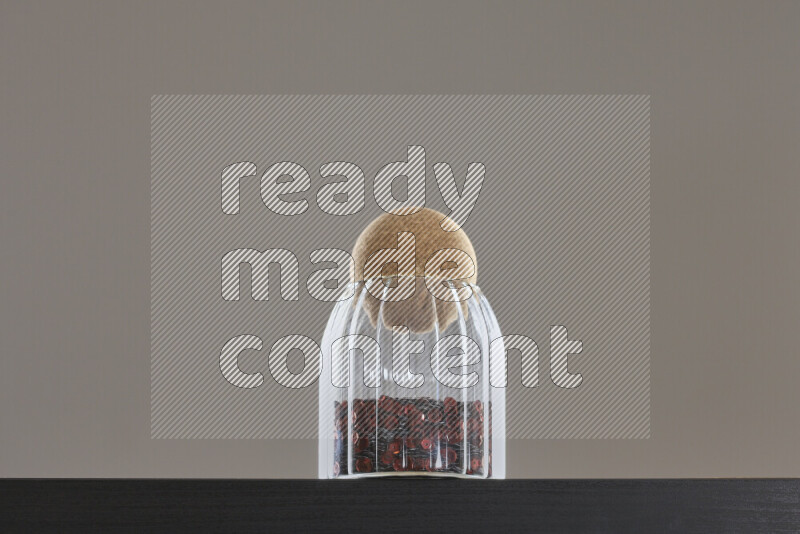 Sequins in a glass jar on black background