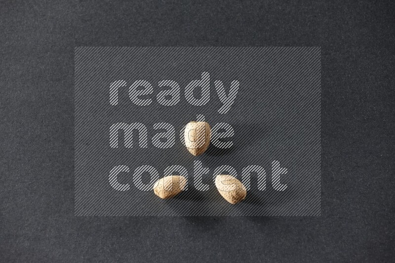 3 almonds on a black background in different angles