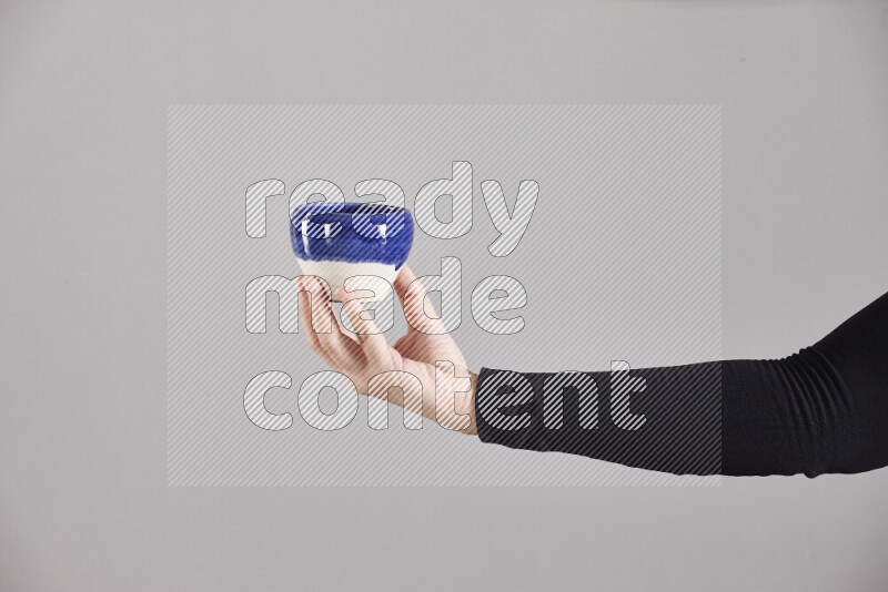 امرأة ترتدي عباءة سوداء تحمل أدوات فخارية مختلفة في أوضاع متعددة