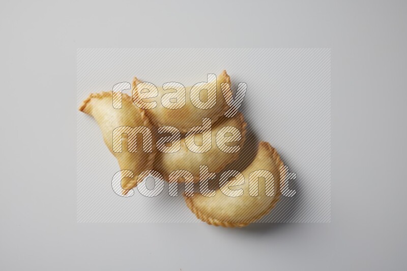 Four fried sambosa from a top angle on a white background