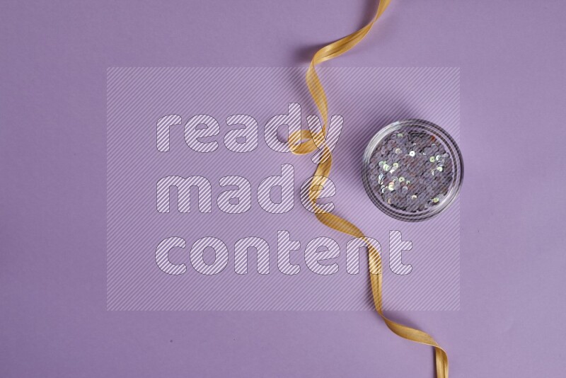 مجموعة من أدوات الخياطة والتفصيل صفراء وأرجوانية اللون على خلفية أرجوانية