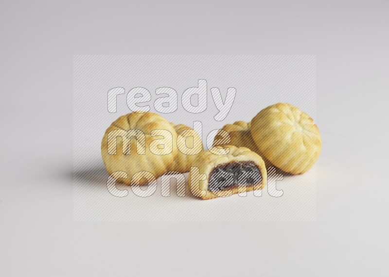 Five Pieces of Maamoul filled with date one of them is cut direct on white background
