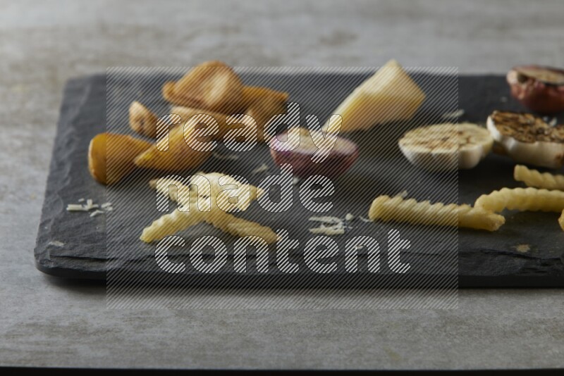 Mixed vegetables on a black stone serving platter on grey textured counter top