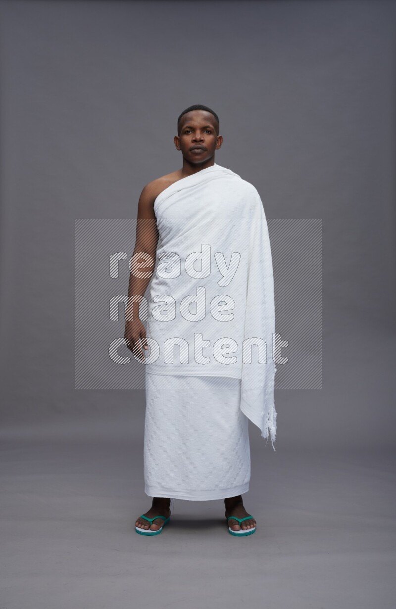 A man wearing Ehram Standing Interacting with the camera on gray background