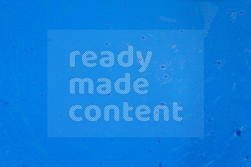 تلتقط الصورة تناثرا للطلاء الأزرق علي خلفية زرقاء